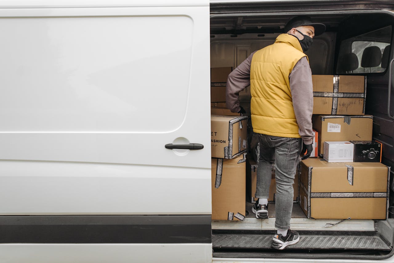 services-01 A deliveryman unloading packages from a van, showcasing modern logistics.
